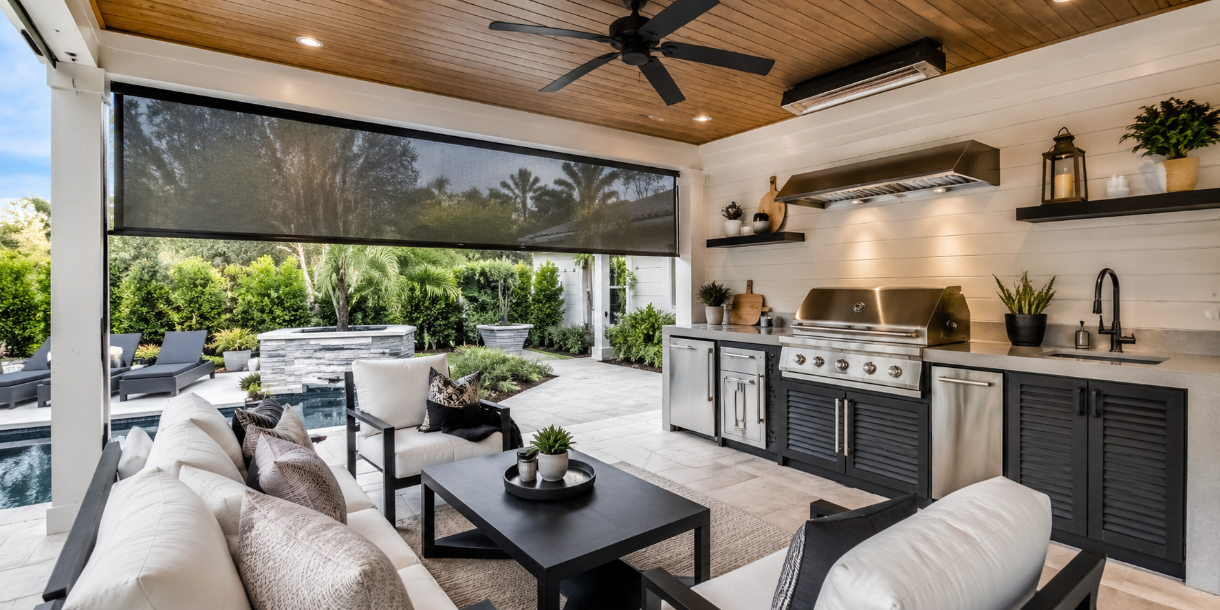 Covered outdoor kitchen with ceiling fan, mounted heater, and roll-down mesh screens.